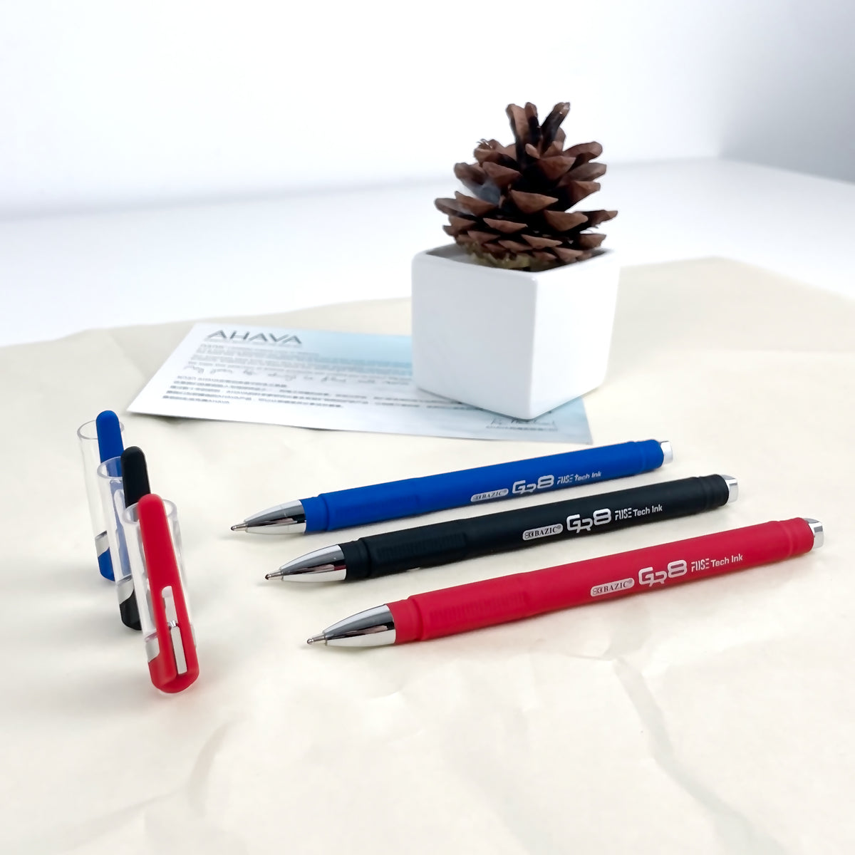 Three blue, black and red pens with silver tips and textured grips, displayed with their clear caps removed.