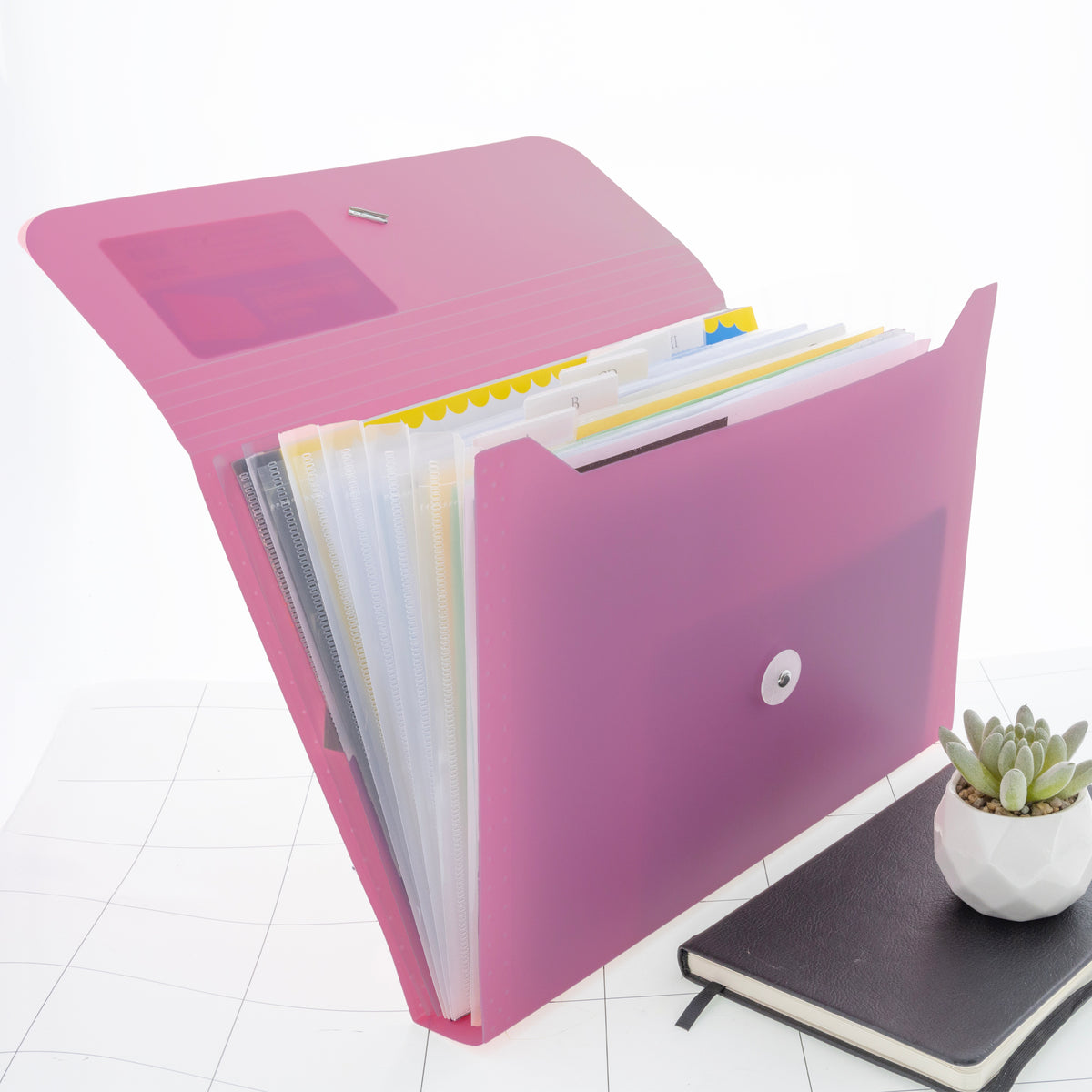 Open pink expanding folder with translucent tabbed pockets holding papers and a snap closure.