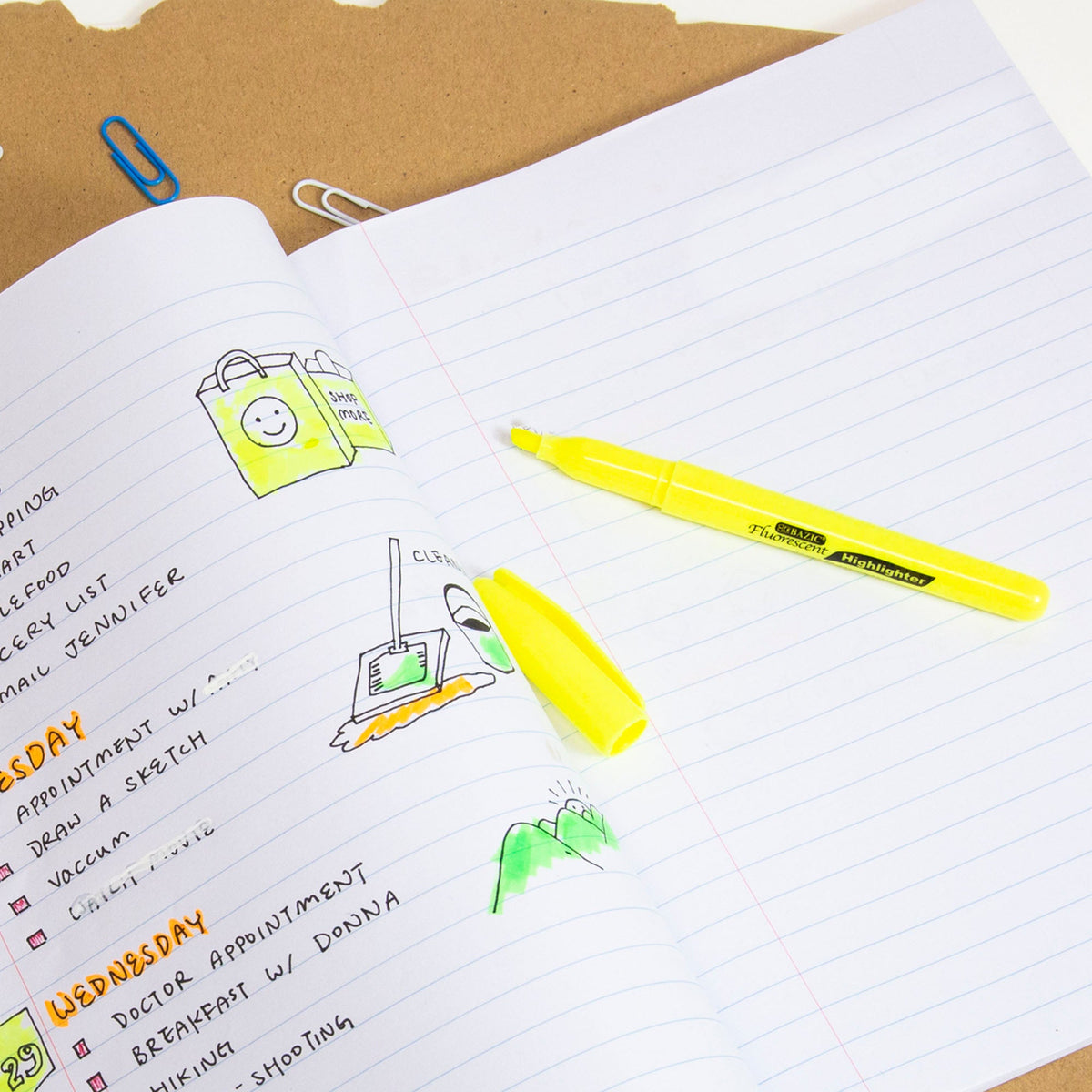 Uncapped yellow highlighter rests on an open lined planner with highlighted notes and colorful drawings.