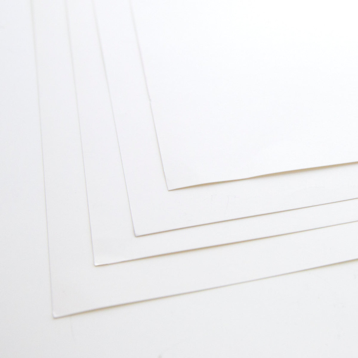 Close-up of overlapping white poster boards showing blank surfaces, straight edges and square corners.