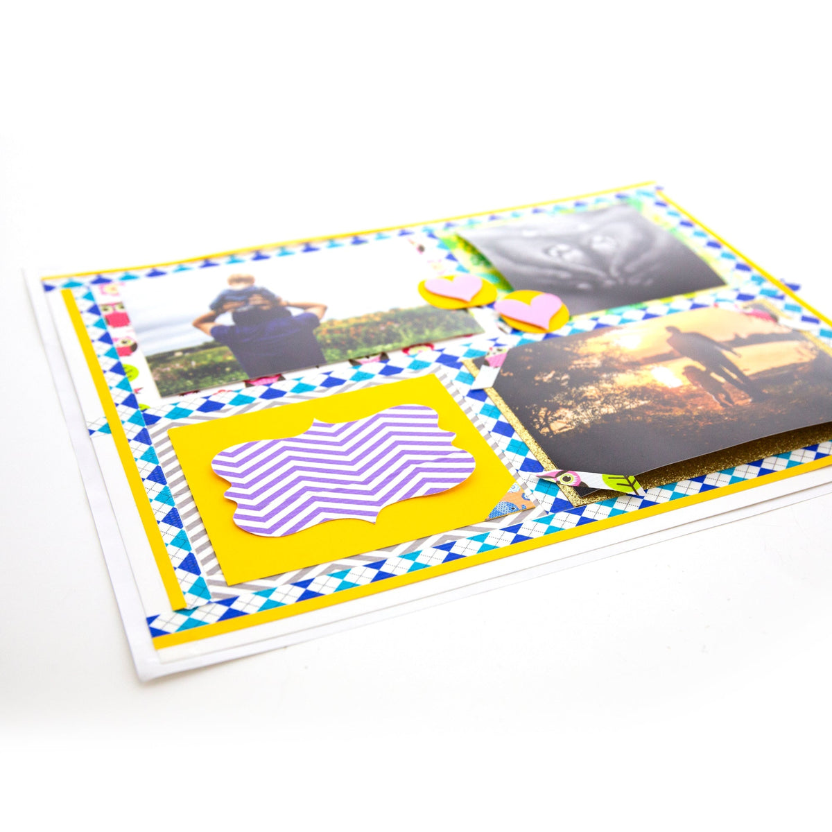 White poster board decorated with three photos, colorful patterned borders, pink hearts and a purple striped cutout.