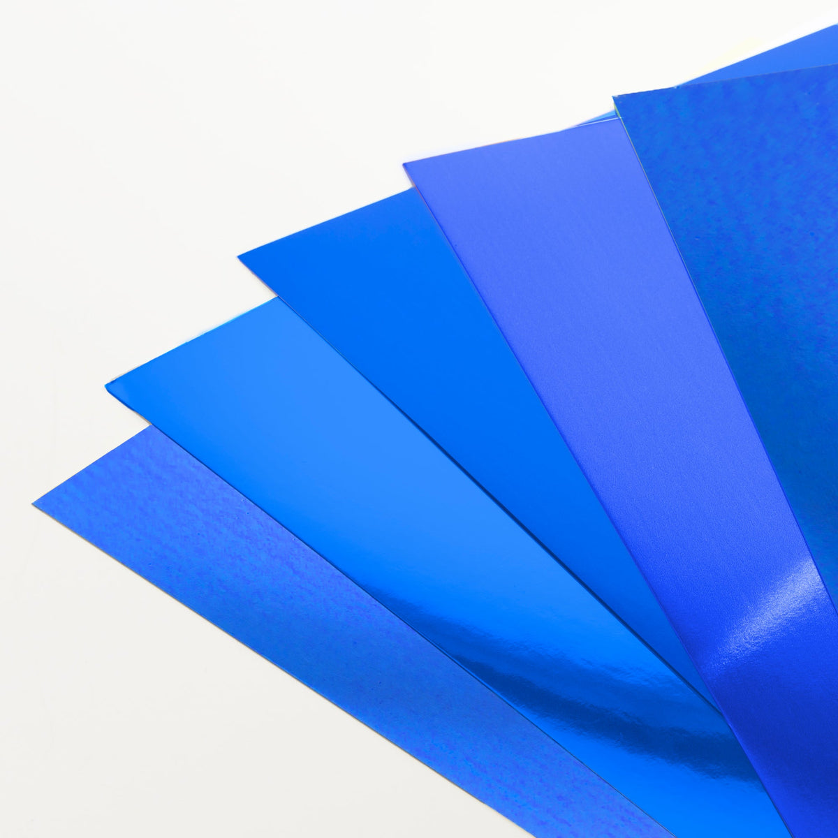 Blue poster boards fanned out in overlapping layers, showing glossy, reflective metallic surfaces.